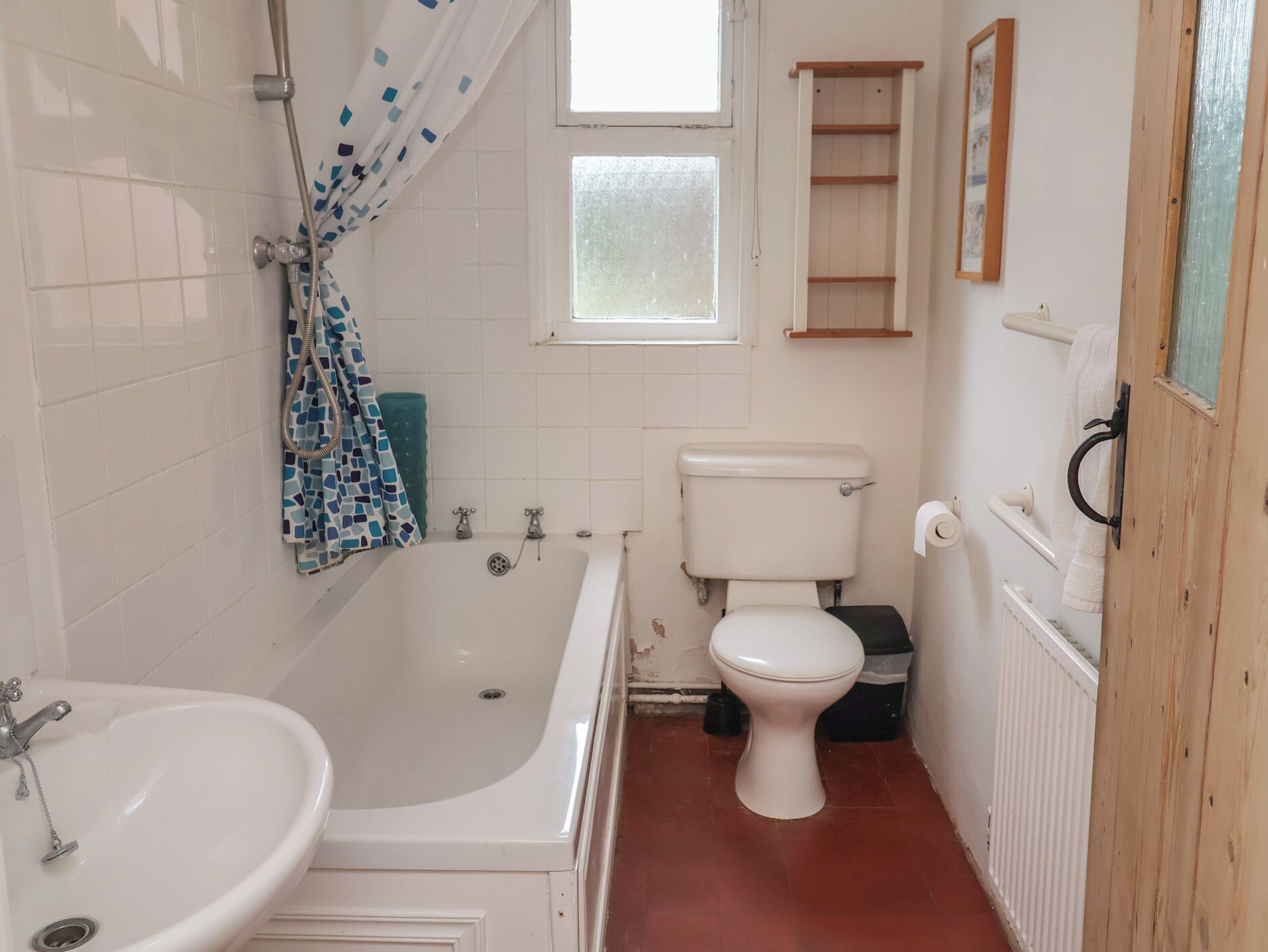 A bathroom with a bathtub, toilet, and sink.