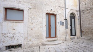 Un bâtiment en pierre avec une porte en bois et une fenêtre.