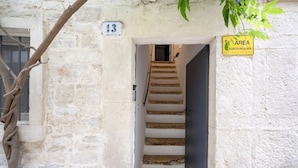 Uma escadaria leva a uma porta com uma placa numerada 13.