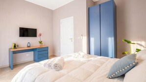 Une chambre à coucher avec un lit, un bureau, une armoire et un téléviseur.
