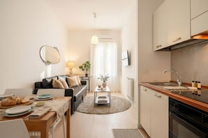 A compact living space with a kitchen, dining area, and a sofa.