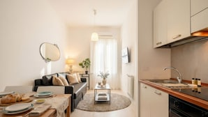 Un espai vital reduït amb cuina, zona de menjador i sofà.