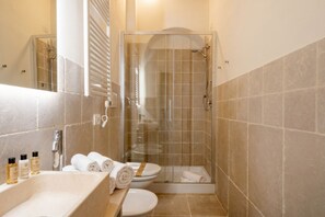 A bathroom with a shower, toilet, and sink.