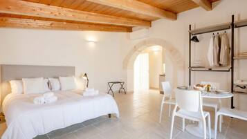 Una camera da letto con un letto grande, un tavolo da pranzo con sedie e un soffitto in legno.