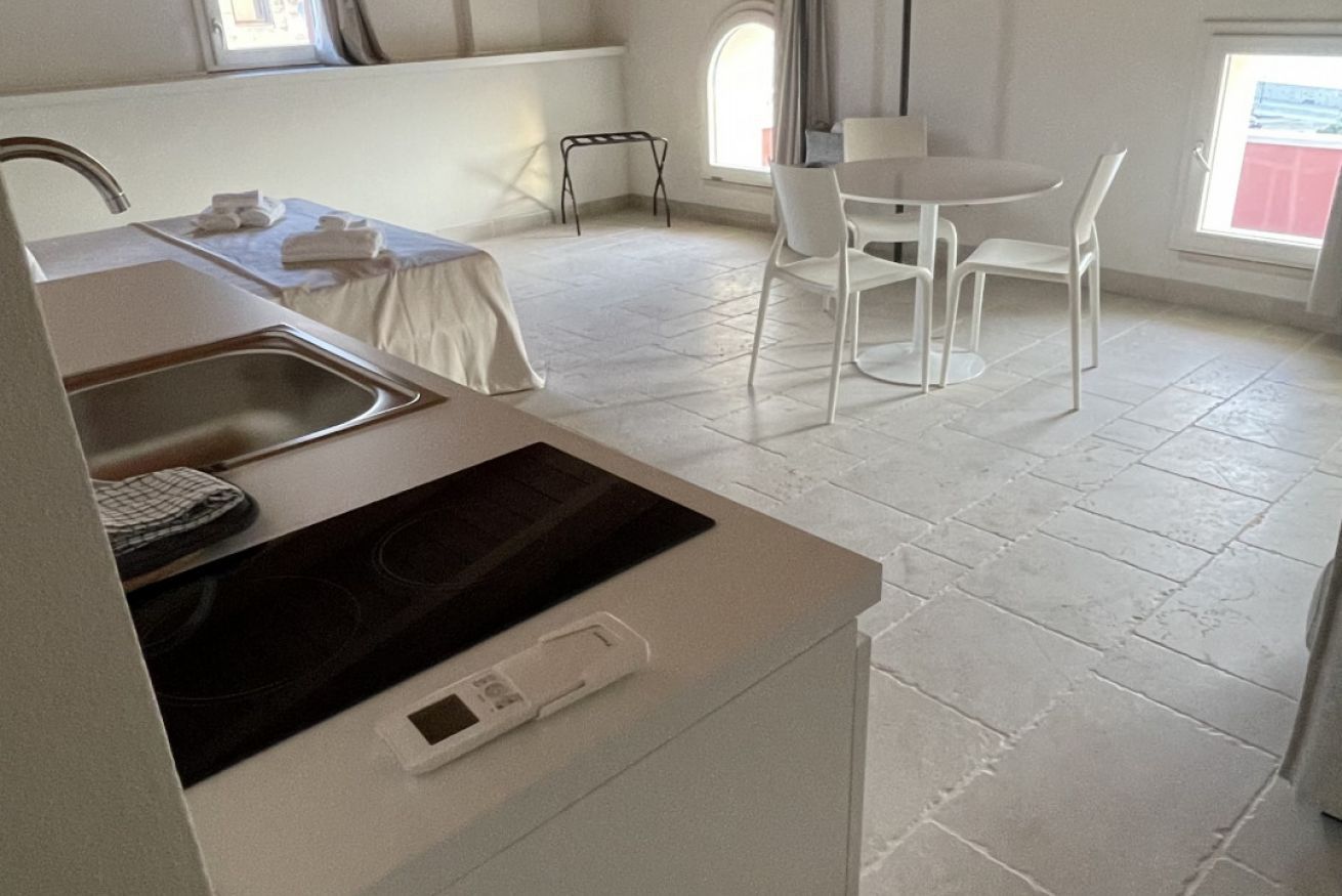 Eine Küche mit Einbauherd, Spüle und Essbereich mit Tisch und Stühlen.