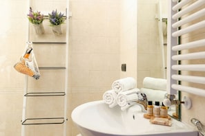 A bathroom with a white sink, towel rack, and a mirror.