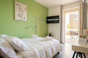 Une chambre d’hôtel avec un lit, une télévision, un bureau et une vue sur l’extérieur.