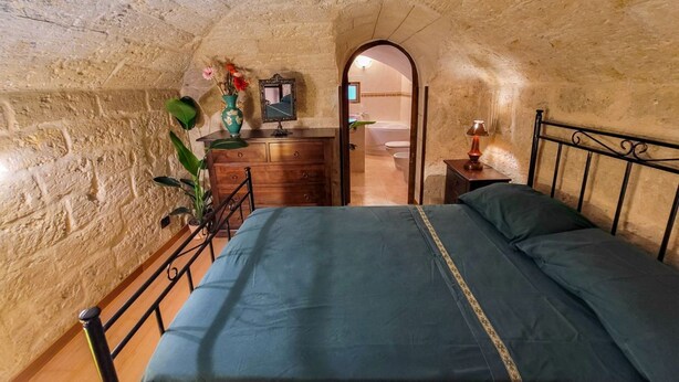A bedroom with a bed, dresser, mirror, and a small table with a lamp. - Sofia - Classical Residence (Bari)