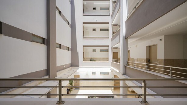 A multi-level interior with a central open space, railings, and a staircase. - Calle Suite - Modern Apartment with Balcony (Bari)