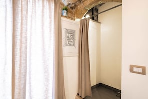 A narrow hallway with a door featuring a black and white drawing, a potted plant on the wall, and a light switch. - Emma - Cozy Residence (Bari)
