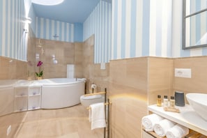 Une salle de bain moderne avec une baignoire sur pieds, des toilettes et un espace douche.
