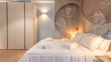 Un dormitorio con cama, luz empotrada en la pared y decoración floral.