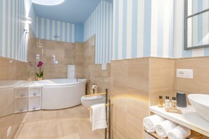 A modern bathroom with a freestanding bathtub, a toilet, and a shower area.
