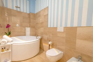A modern bathroom with a freestanding bathtub, a toilet, and a sink.