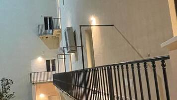Un interno a più livelli con una scala, balconi e una ringhiera.
