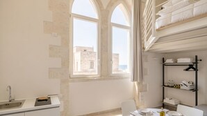 A modern kitchen with a built-in oven, a sink, and a dining area with a table set for two.