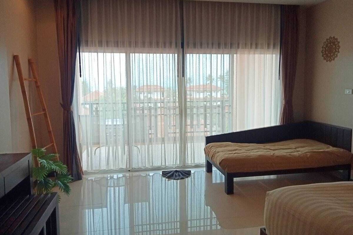 A modern bedroom with a large window, a bed, a bench, and a ladder.