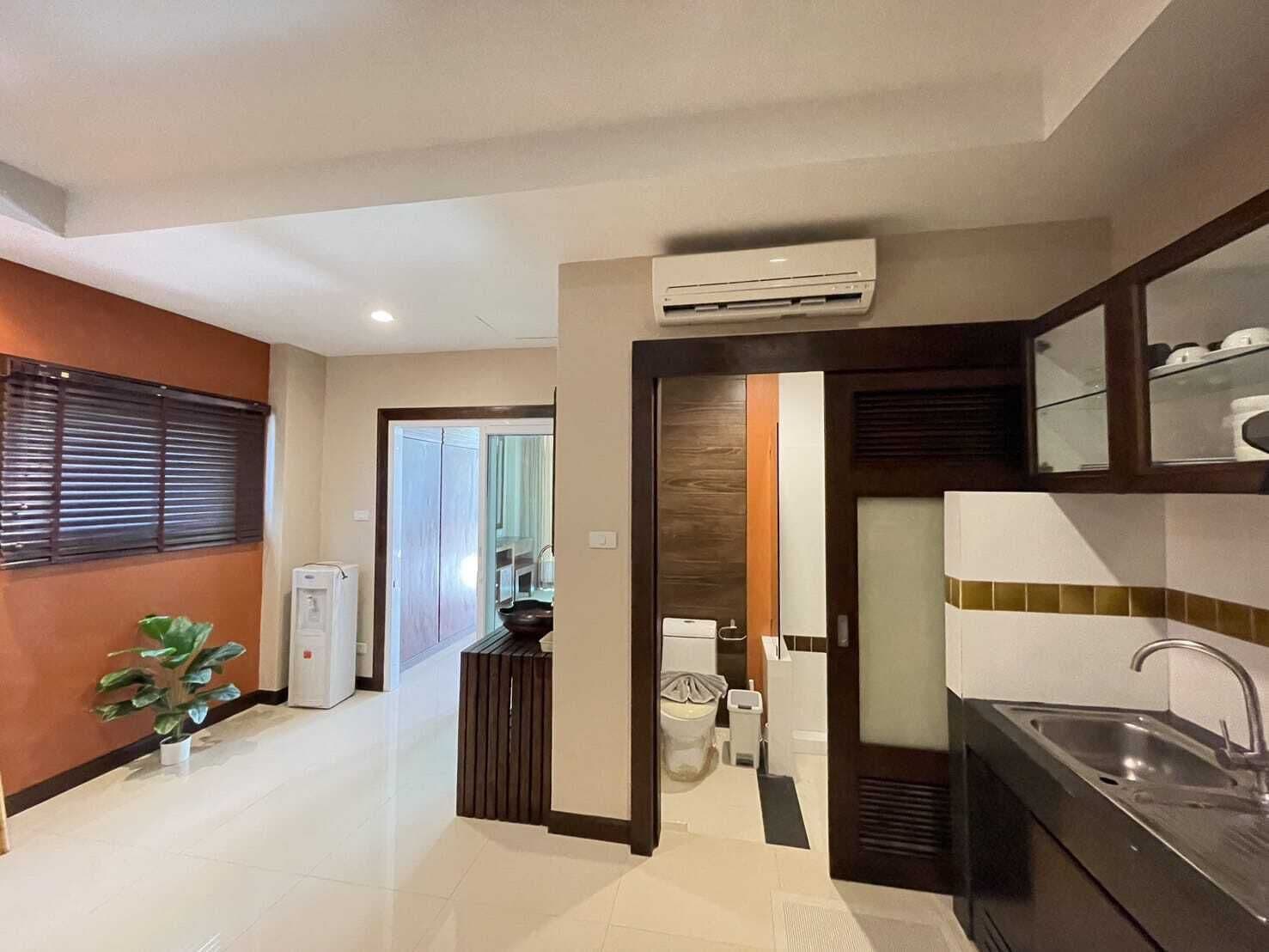 A modern kitchen with a built-in sink, a microwave, and an air conditioning unit above the counter.