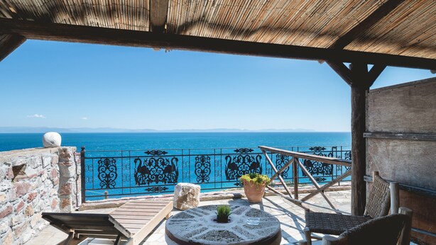 A wooden deck with a view of the sea, a stone wall, and a metal railing. - Apartment 'Castle Rizaraki 206' with Sea View, Wi-Fi and Air Conditioning (Γύθειο)