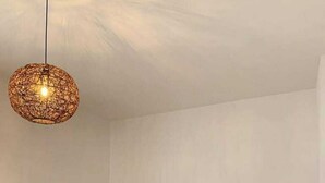 Ein Schlafzimmer mit einem Bett, zwei Nachttischen, einer Hängeleuchte und einem Holzkopfende.