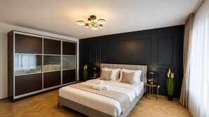 Quarto moderno com uma cama grande, um guarda-roupa e uma luminária no teto.