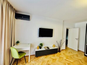 Una scrivania, postazione laptop, tende oscuranti, ferro/asse da stiro