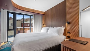 A modern hotel room with a large bed, a wooden desk, and a view of the city through a sliding glass door. - George Hotel Launceston, An Ascend Collection Hotel (Launceston)
