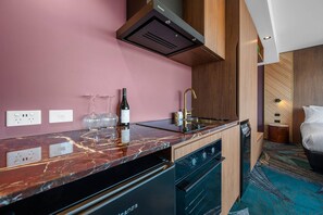 A modern kitchen with a marble countertop, built-in dishwasher, and a compact sink. - George Hotel Launceston, An Ascend Collection Hotel (Launceston)