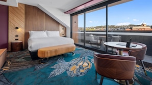 A hotel room with a large bed, a round table, and a view of the cityscape. - George Hotel Launceston, An Ascend Collection Hotel (Launceston)