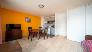 A compact living space with a dining area, kitchenette, and a television. - Charming Apart for 6 near the Ski Slopes (Allos)