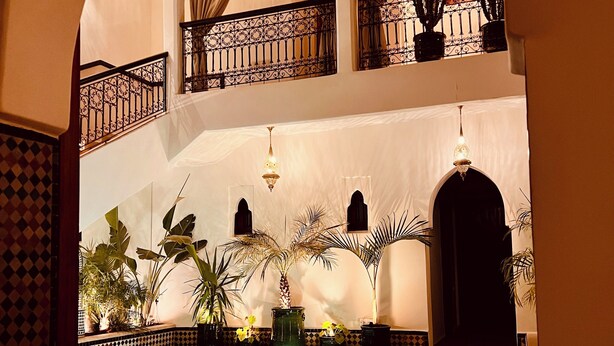 An indoor swimming pool with a tiled floor, surrounded by potted plants and a decorative railing. - Magnificent Villa-Riad with private garden, large Jacuzzi in a private estate (Marrakech)