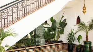 A pool area with a tiled floor, a staircase with ornate railings, and potted plants. - Magnificent Villa-Riad with private garden, large Jacuzzi in a private estate (Marrakech)