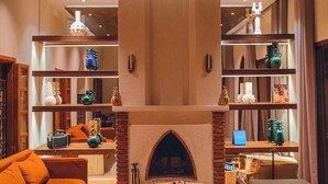 A cozy living room with a fireplace, a sofa, a coffee table, and a bookshelf. - Magnificent Villa-Riad with private garden, large Jacuzzi in a private estate (Marrakech)