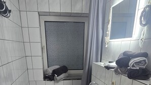 A bathroom with a bathtub, toilet, sink, and a mirror. - Beautiful vacation apartment in Timmendorfer Strand (Timmendorfer Strand)