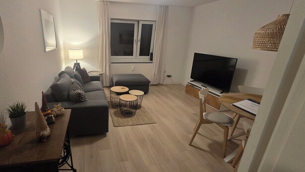 A compact living space with a sofa, a small table, a TV, and a dining area. - Beautiful vacation apartment in Timmendorfer Strand (Timmendorfer Strand)