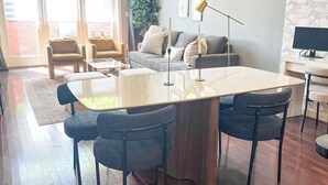 Ein modernes Wohnzimmer mit großem Holzesstisch, bequemen Sitzmöglichkeiten und einem Kamin.