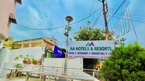 Une enseigne pour la chaîne d’hôtels et de complexes hôteliers AA, indiquant les services proposés, notamment des chambres, un restaurant, une salle de banquet et un parking.
