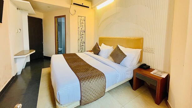 Une chambre d’hôtel équipée d’un lit, d’une table de chevet et d’un appareil de climatisation.