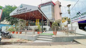 Un bâtiment sur lequel on peut lire les enseignes « Flavours Sweets Bakery » et « Hôtel Ashwin ».