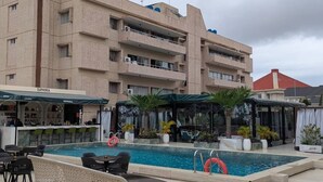 Ein Hotel mit Schwimmbad, Außenbereich zum Sitzen und einer Bar.