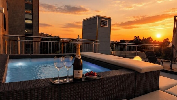 A rooftop pool with lounge seating, a bottle of champagne, and a bowl of fruit. - CA' SAN CRISTOFORO (Milan)