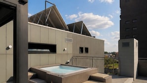 A rooftop terrace with a hot tub, seating area, and a view of a cityscape. - CA' SAN CRISTOFORO (Milan)