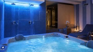 A spa room with a hot tub, blue-tiled walls, and recessed ceiling lights. - CA' SAN CRISTOFORO (Milan)