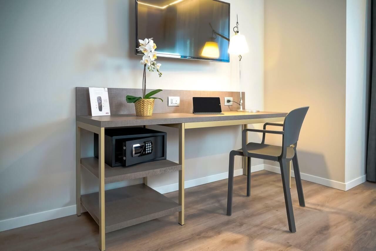 Ein moderner Arbeitsplatz mit Schreibtisch, Stuhl und einem Wand-Fernseher.