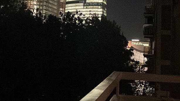 A nighttime view of a cityscape with illuminated buildings, including a construction crane and a building with a sign that reads "CityLife." - Apartment 2 minutes from Mico/FieraMilano and Citylife (MM5) (Milano)