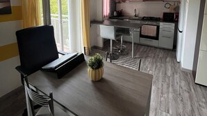A compact kitchen with red cabinets, a dining area with a table and chairs, and a small potted plant on the table. - Apartment 2 minutes from Mico/FieraMilano and Citylife (MM5) (Milano)