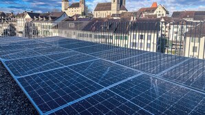 Solar panels on a rooftop with a historic building in the background. - Castle apartment in the center of Rapperswil - Schnydershome (Rapperswil-Jona)