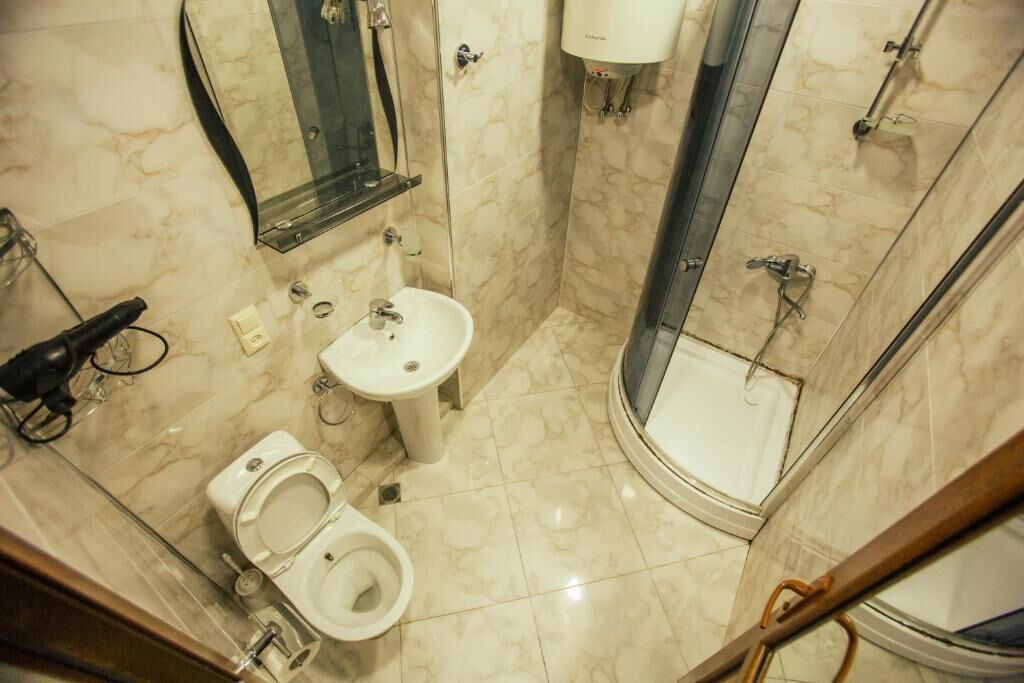 A bathroom with a toilet, sink, and shower.