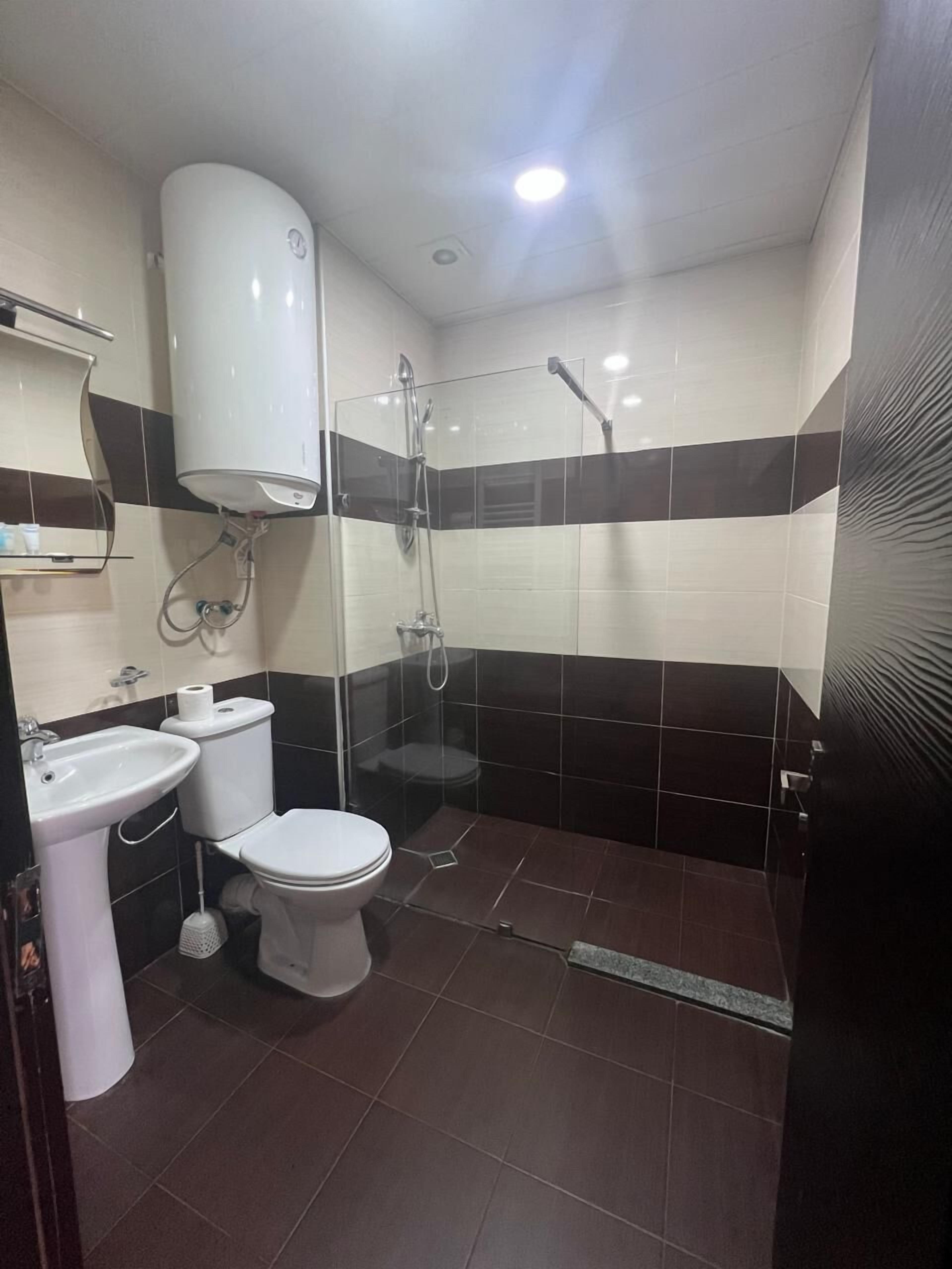 A bathroom with a toilet, sink, and shower.