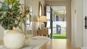 A hallway with a wooden bench, a lamp, and a mirror. - Coastal Drift – your Jervis Bay escape starts here (Callala Bay)